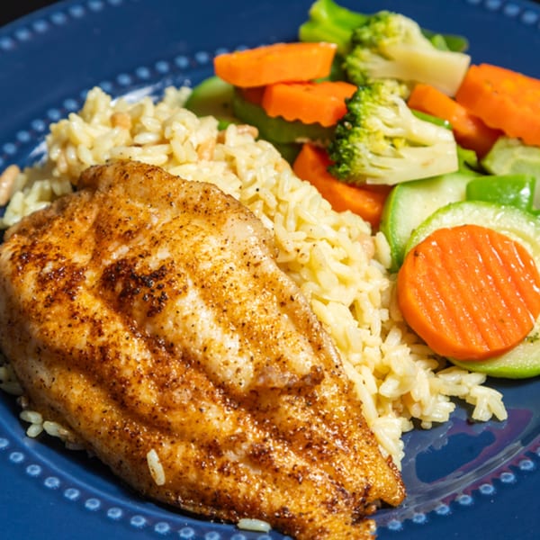 Seasoned chicken breast with rice pilaf and mixed vegetables on a blue plate at Grille No. 13.